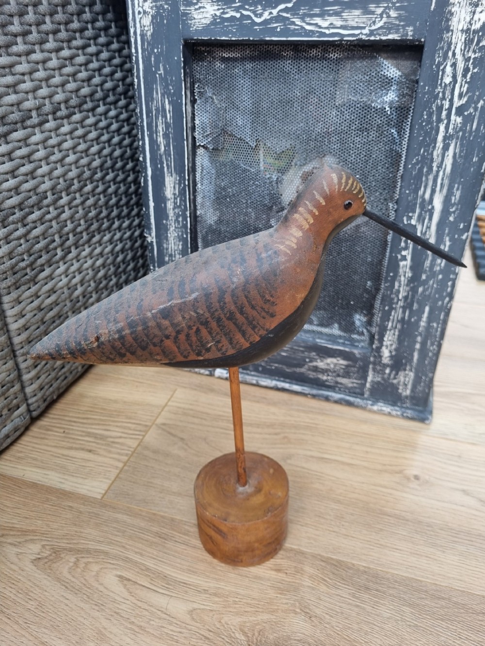a wooden stalking bird on a stand
